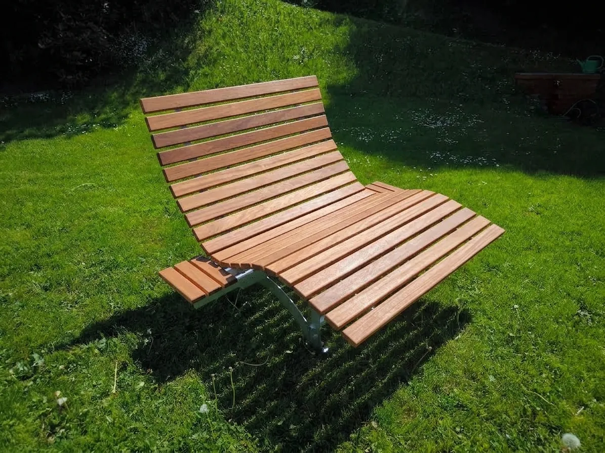 Ergonomisches Waldsofa als Wellenliege in 120 cm Breite mit Latten aus wetterfestem Bangkirai-Holz und zwei ausklappbaren Seitentischen.